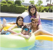 Family enjoying pool time with child on inflatable at AIPL DreamCity Ludhiana