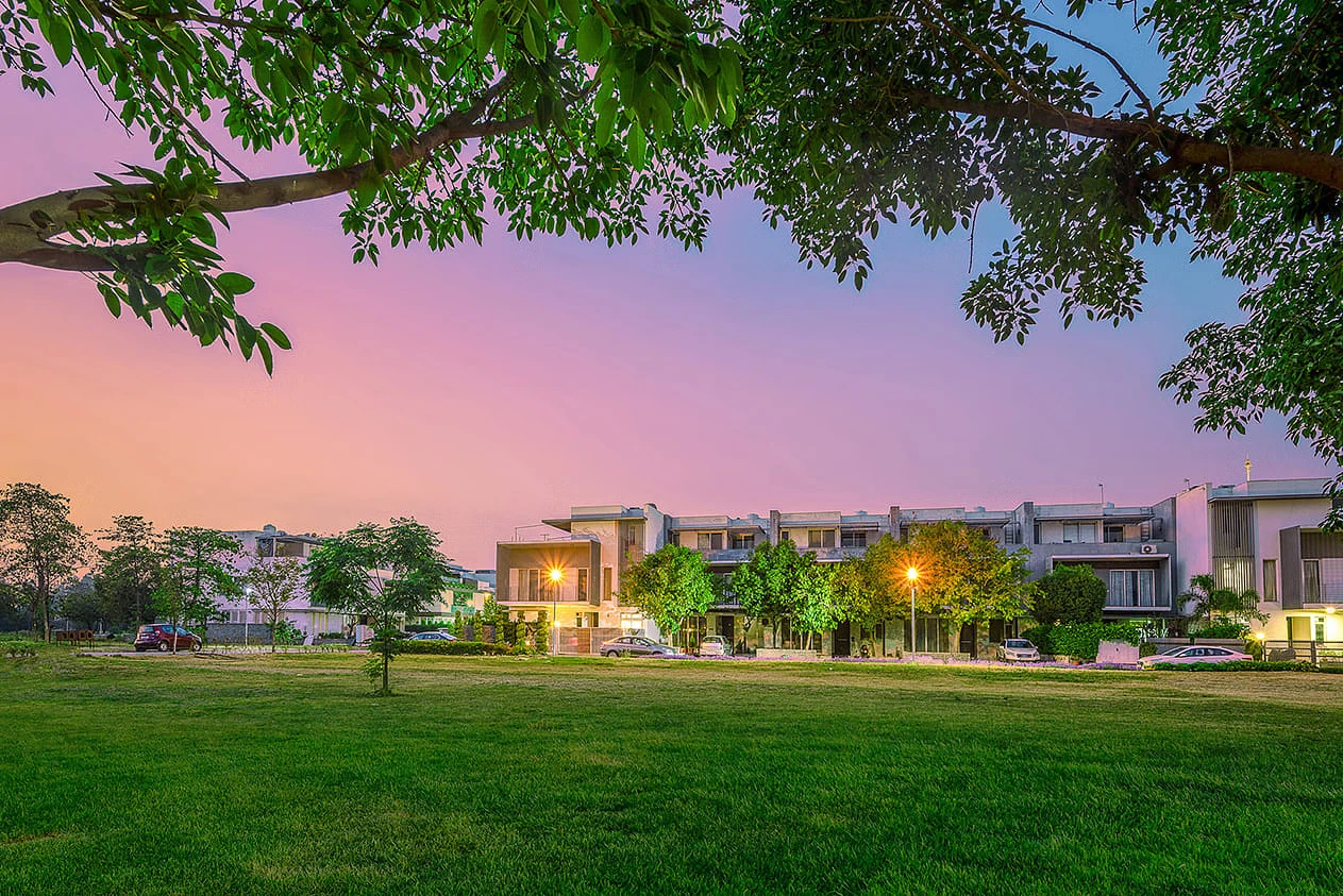 AIPL DreamCity Ludhiana at dusk, with modern houses and green spaces