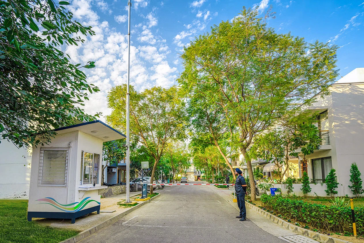 A security guard standing in front of a gate at AIPL DreamCity, Ludhiana